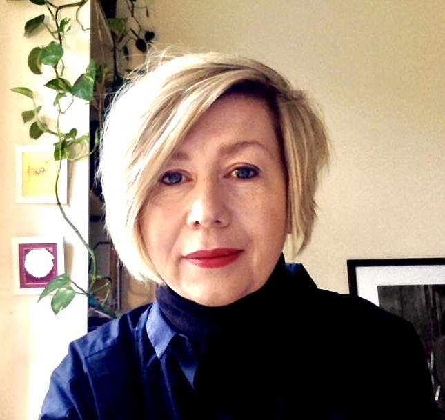 A photograph of Vikki Hill - a white woman with blonde hair in a blue shirt.